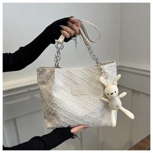 Détail du sac cabas en tweed blanc avec chaîne en métal et pendentif lapin mignon