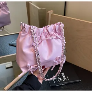 Sac seau rose à cordon avec nœuds délicats et détail de bandoulière en chaîne argent