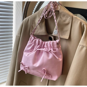 Petit sac seau plissé rose avec nœuds décoratifs et bandoulière chaîne argentée