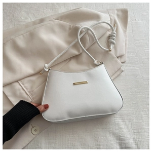 Détail du sac à bandoulière blanc minimaliste avec boucle dorée et bandoulière à nœuds