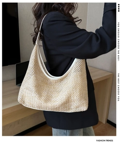 Close-up of the woven mesh texture and white leather strap on this large straw tote bag