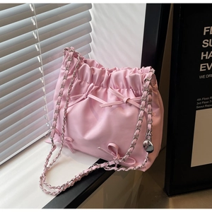 Détail du sac seau rose en cuir PU avec des nœuds mignons et bandoulière chaîne
