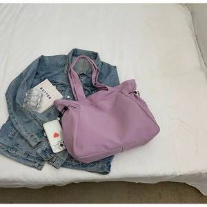 Detail of lavender tote bag with side drawstrings on a stylish casual setting