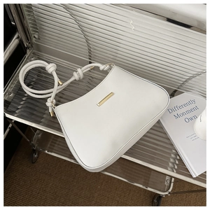 Détail du sac demi-lune blanc avec bandoulière nouée et garniture métallique dorée