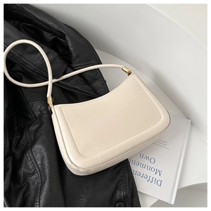 Detail of cream white half-moon bag with golden metal buckle and smooth leather texture