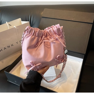 Sac seau rose plissé avec nœuds décoratifs et bandoulière chaîne dans un coffret cadeau