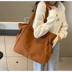 Detailed side view of brown large oxford tote bag with stylish drawstring details