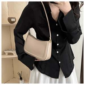 Close-up of minimalist beige hobo bag with smooth PU leather and gold hardware detail