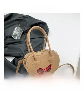 Close-up of heart-shaped handbag featuring butterfly prints and polished zipper detail