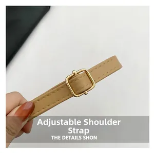 Detail of adjustable faux leather shoulder strap with gold buckle and precise stitching
