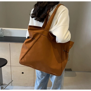 Vue arrière d'un grand sac cabas marron avec cordons de serrage sur fond minimaliste