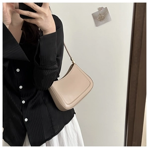 Mirror selfie showing a solid beige leather hobo shoulder bag with a black and white outfit