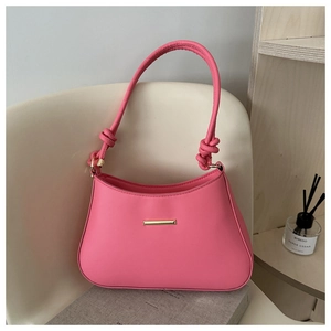 Vue détaillée du sac à bandoulière rose fuchsia avec bandoulière nouée et boucle dorée