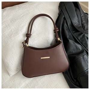 Détails de ce sac à bandoulière en similicuir marron avec sangle nouée et boucle dorée