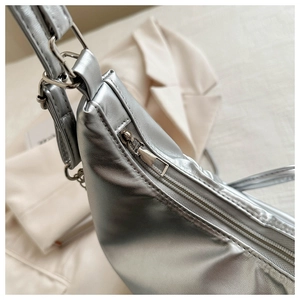 Macro shot of silver pleated tote bag featuring high-shine metallic finish and smooth zipper