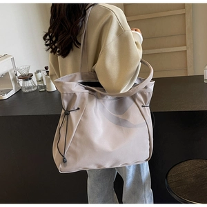 Détail du grand sac cabas beige-gris avec cordons de serrage latéraux fonctionnels