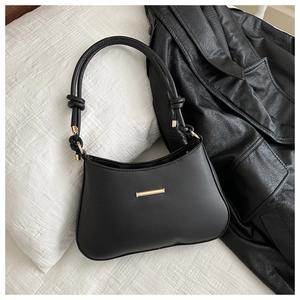 Détail du sac à bandoulière en cuir noir avec poignée nouée et garniture en métal doré