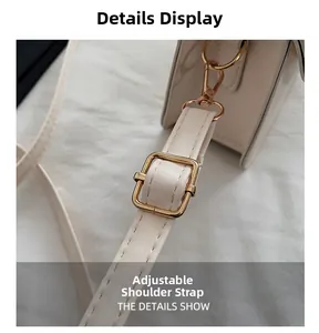 Close-up of adjustable strap with gold metal buckle on beige stone-pattern handbag