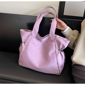 Detail of light purple nylon tote bag featuring adjustable black side drawstrings