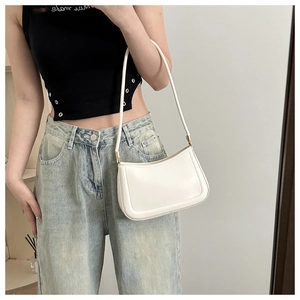Minimalist ivory white shoulder bag shown on model with sleek baguette styling