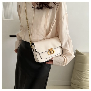 Détail d'un sac bandoulière crème chic avec boucle dorée CD et bandoulière en chaîne