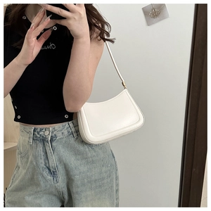 Mirror selfie showing the white minimalist half-moon underarm bag worn by a model