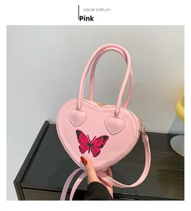 Pink heart-shaped handbag featuring red butterfly print and elegant gold hardware details