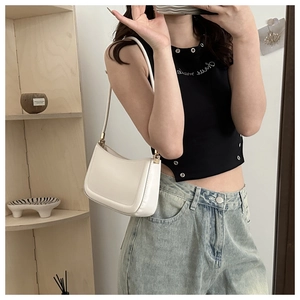 Minimalist creamy white underarm bag shown in a lifestyle shoulder carry pose