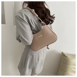 Détail d'un sac hobo beige élégant avec bandoulière nouée et finitions dorées
