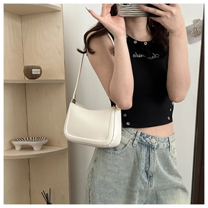 Minimalist white matte leather shoulder bag held by a model in casual attire
