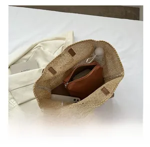 Top view of woven straw tote bag with brown zipper inner pouch showing spacious interior