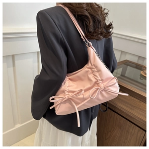 Close-up of pink tote bag featuring elegant bow accents and pleated texture detail