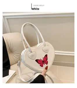 Detail of white heart-shaped handbag with butterfly print and heart-shaped handle stitching