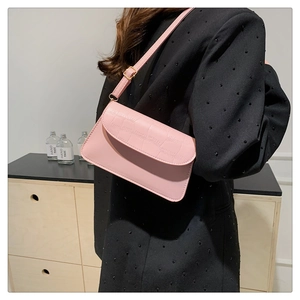 Detail of pink faux leather bag showing crocodile embossed texture and adjustable strap