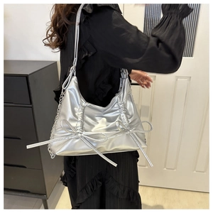 Silver metallic bow tote bag with pleated texture and side metal chain detail