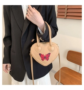 Chic beige heart shaped handbag featuring red butterfly embroidery and dual straps
