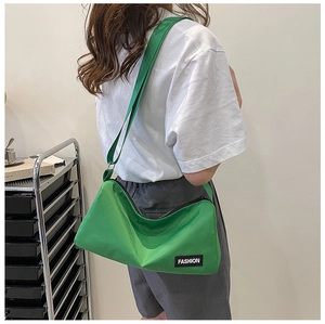 Detail of green lightweight oxford cloth crossbody bag with fashion woven label strap