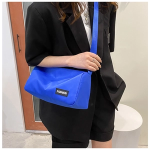 Blue cylindrical oxford crossbody bag shown on model for a stylish modern look