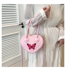 Pink heart-shaped handbag featuring butterfly embroidery and adjustable shoulder strap