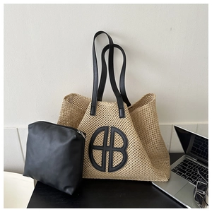 Detail of woven straw tote bag with black leather straps and matching zip pouch