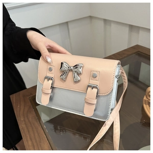 Detail of pink and silver crossbody bag with metallic finish and bow accent
