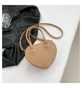Detailed top view of a beige heart-shaped handbag with matching leather patches and straps