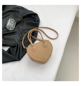 Detail view of the khaki heart-shaped handbag with matte PU leather and thin strap