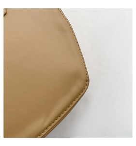 Close-up of khaki leather bag featuring detailed stitching and premium lychee texture