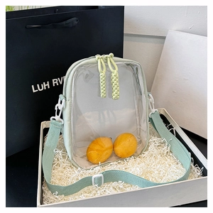 Detail view of mint green nylon crossbody bag with clear window and woven rope zipper pulls