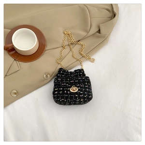 Top view of mini black tweed crossbody bag with golden chain and rotary lock detail
