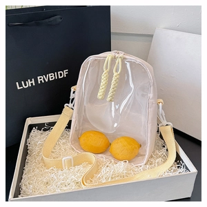 Detailed view of cream and yellow nylon crossbody bag inside a white gift box