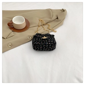 Close-up of elegant mini tweed shoulder bag with gold chain and metal twist lock