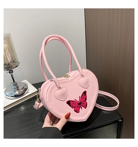 Pink heart-shaped PU leather handbag featuring a butterfly print and gold zipper detail
