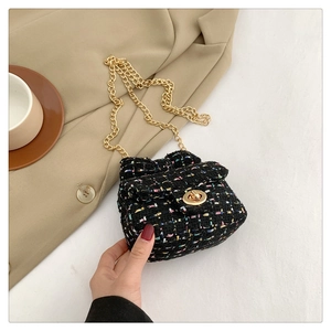 Detail of tweed crossbody bag with golden chain strap and metallic rotary lock